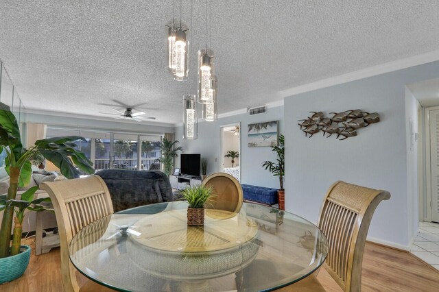 1858 SW Palm City Rd Unit 205, Stuart, FL 34994 - dining area with ceiling fan, a textured ceiling, crown molding, and wood finished floors