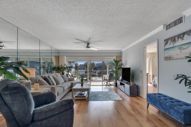 1858 SW Palm City Rd Unit 205, Stuart, FL 34994 - living area featuring ceiling fan, crown molding, light wood-style floors, and a textured ceiling