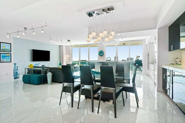 2640 Lake Shore Dr Unit 2307, Riviera Beach, FL 33404 - dining area with a chandelier, light marble finish floors, and rail lighting