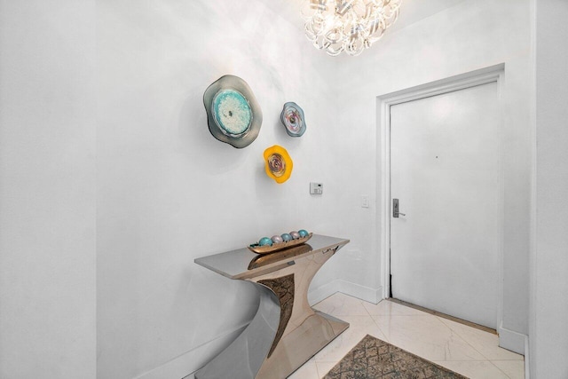 2640 Lake Shore Dr Unit 2307, Riviera Beach, FL 33404 - entrance foyer featuring a chandelier, light marble finish floors, and baseboards