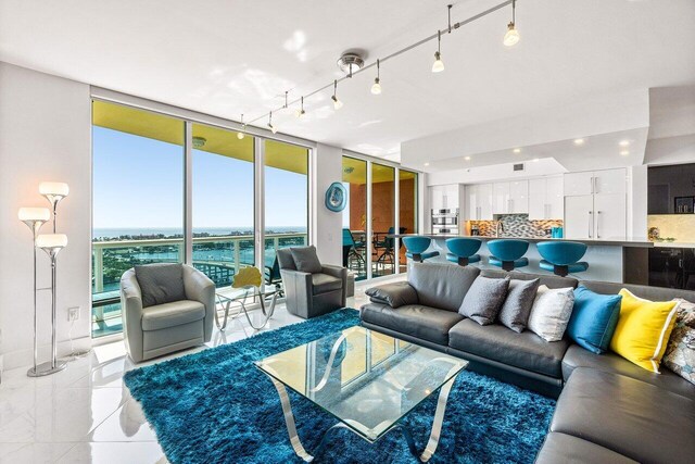 2640 Lake Shore Dr Unit 2307, Riviera Beach, FL 33404 - living room featuring a wall of windows, rail lighting, and a water view