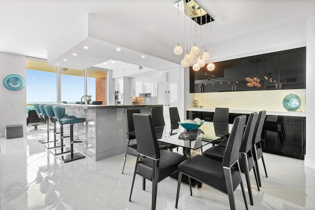 2640 Lake Shore Dr Unit 2307, Riviera Beach, FL 33404 - dining room with a chandelier, light marble finish flooring, recessed lighting, and expansive windows
