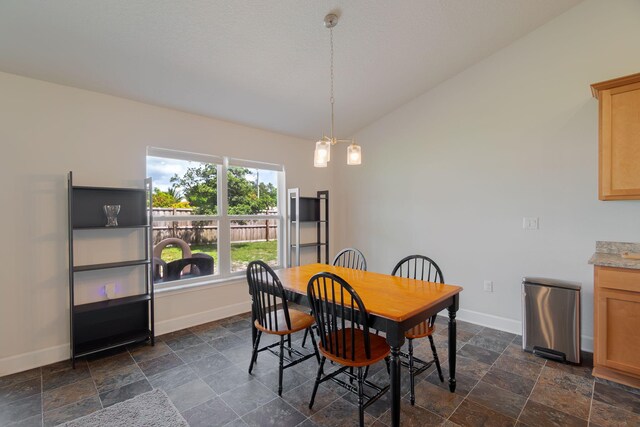 517 SW Cherryhill Rd, Port Saint Lucie, FL 34953 - dining space featuring vaulted ceiling, baseboards, and dark stone finish flooring