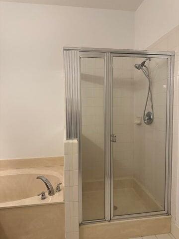 10280 SW Stephanie Way Unit 8209, Port Saint Lucie, FL 34987 - bathroom featuring a shower stall, a bath, and tile patterned floors