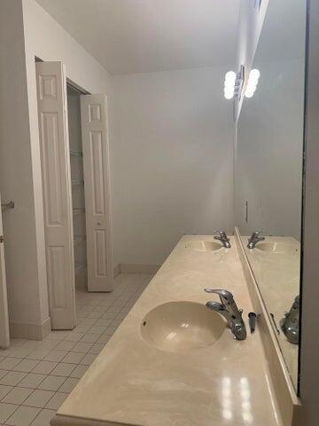 10280 SW Stephanie Way Unit 8209, Port Saint Lucie, FL 34987 - bathroom with tile patterned flooring, double vanity, and baseboards