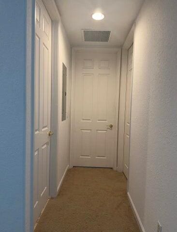 10280 SW Stephanie Way Unit 8209, Port Saint Lucie, FL 34987 - hallway featuring light colored carpet, a textured wall, and baseboards