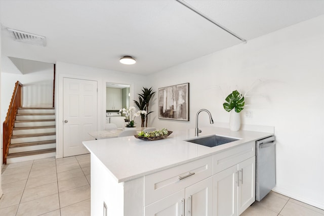 744 Buttonwood Ln Unit 411-D, Boynton Beach, FL 33436 - kitchen featuring a sink, dishwasher, light tile patterned floors, light countertops, and white cabinetry