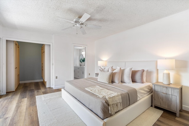 744 Buttonwood Ln Unit 411-D, Boynton Beach, FL 33436 - bedroom featuring wood finished floors, a textured ceiling, a ceiling fan, baseboards, and connected bathroom