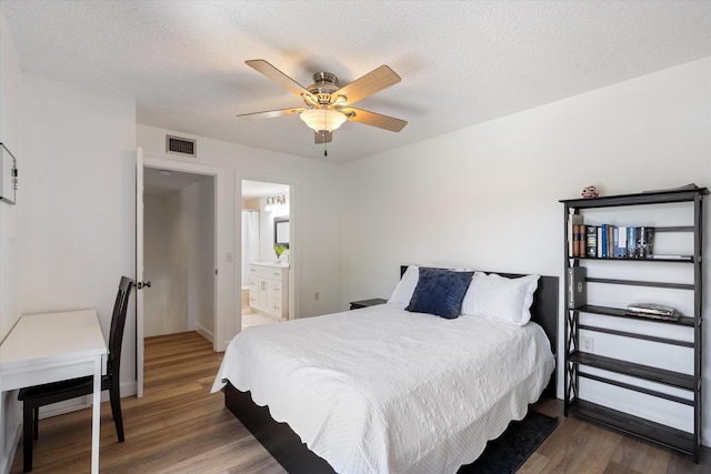 744 Buttonwood Ln Unit 411-D, Boynton Beach, FL 33436 - bedroom with wood finished floors, ceiling fan, baseboards, ensuite bathroom, and a textured ceiling