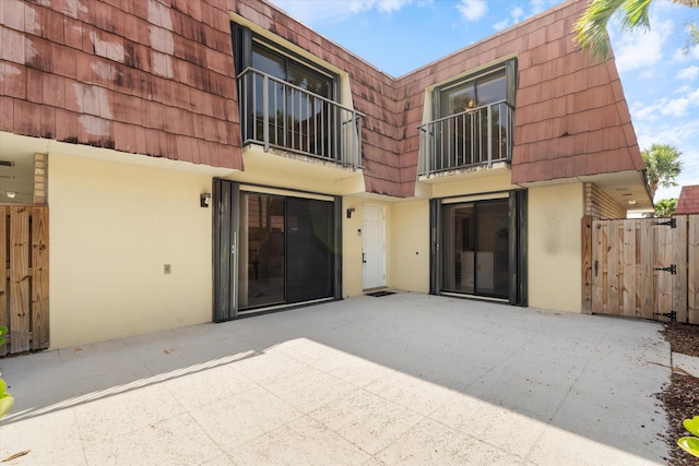 744 Buttonwood Ln Unit 411-D, Boynton Beach, FL 33436 - rear view of property featuring mansard roof, stucco siding, and a balcony