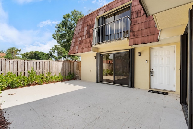 744 Buttonwood Ln Unit 411-D, Boynton Beach, FL 33436 - property entrance with mansard roof, stucco siding, a patio area, and a balcony