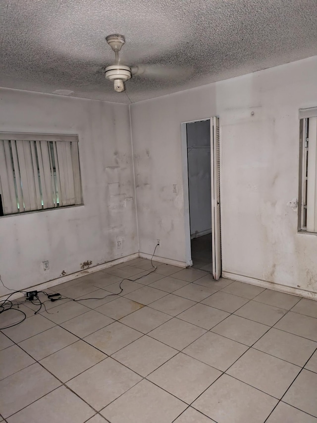 3900 Kenas St, West Palm Beach, FL 33403 - spare room with a textured ceiling, light tile patterned floors, and baseboards