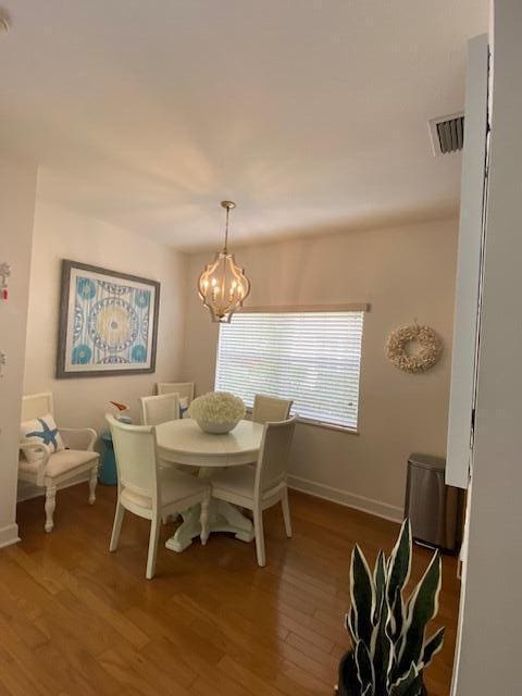 4240 Gator Trace Ave Unit 0, Fort Pierce, FL 34982 - dining area featuring a chandelier, wood finished floors, and baseboards
