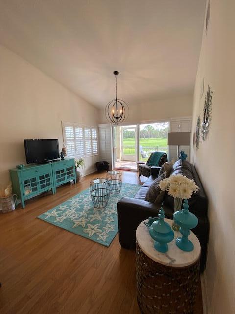4240 Gator Trace Ave Unit 0, Fort Pierce, FL 34982 - living room featuring wood finished floors, a chandelier, and lofted ceiling