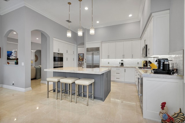101 Sedona Way, Palm Beach Gardens, FL 33418 - kitchen with appliances with stainless steel finishes, crown molding, light marble finish floors, backsplash, and a kitchen breakfast bar