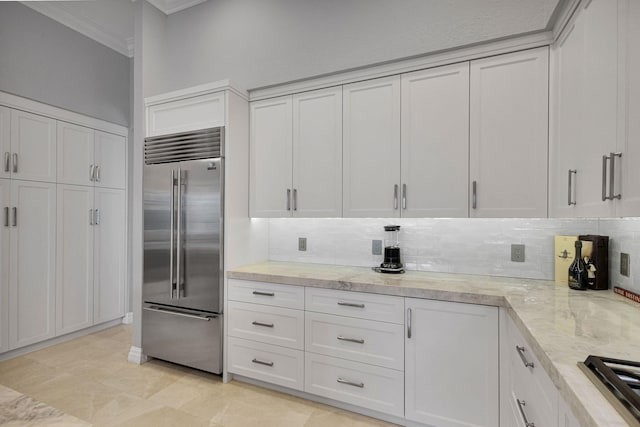 101 Sedona Way, Palm Beach Gardens, FL 33418 - kitchen with appliances with stainless steel finishes, ornamental molding, backsplash, white cabinets, and light stone countertops