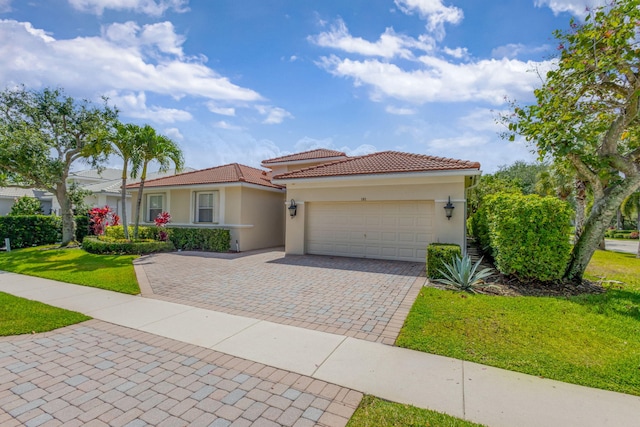 101 Sedona Way, Palm Beach Gardens, FL 33418 - mediterranean / spanish home featuring decorative driveway, an attached garage, stucco siding, a front yard, and a tile roof