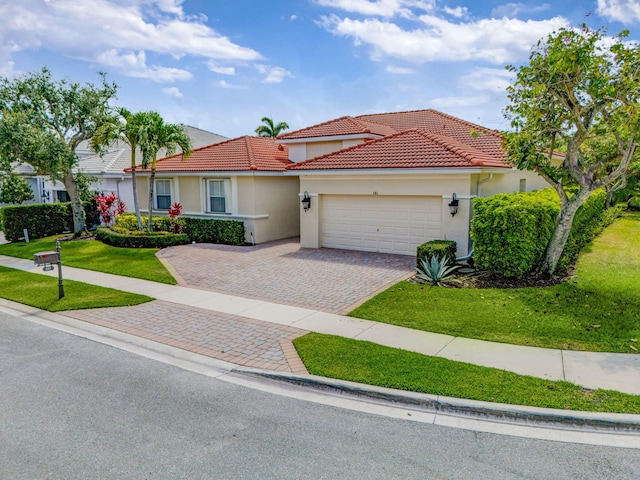 101 Sedona Way, Palm Beach Gardens, FL 33418 - mediterranean / spanish-style house with a tiled roof, an attached garage, decorative driveway, and a front lawn