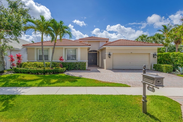 101 Sedona Way, Palm Beach Gardens, FL 33418 - view of front facade with stucco siding, an attached garage, decorative driveway, a tiled roof, and a front lawn