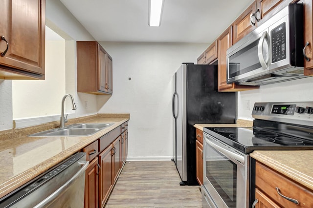 5171 Glencove Ln, West Palm Beach, FL 33415 - kitchen featuring appliances with stainless steel finishes, a sink, light wood-type flooring, and light countertops