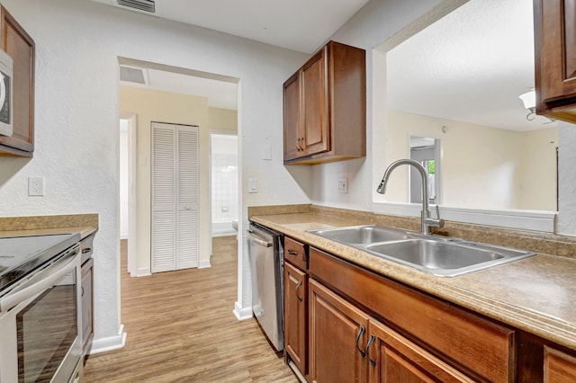 5171 Glencove Ln, West Palm Beach, FL 33415 - kitchen with appliances with stainless steel finishes, a sink, light wood-style flooring, light countertops, and baseboards