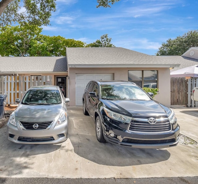 5171 Glencove Ln, West Palm Beach, FL 33415 - view of front facade featuring a garage, a shingled roof, concrete driveway, and stucco siding