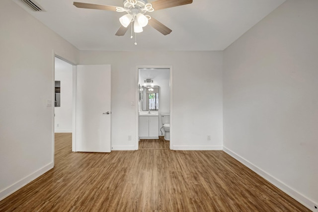 5171 Glencove Ln, West Palm Beach, FL 33415 - unfurnished bedroom with baseboards, wood finished floors, ensuite bathroom, and ceiling fan