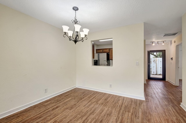 5171 Glencove Ln, West Palm Beach, FL 33415 - spare room featuring a chandelier, dark wood-style floors, baseboards, and track lighting
