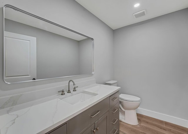 18228 48th Ave N, The Acreage, FL 33470 - bathroom with wood finished floors, toilet, vanity, and baseboards