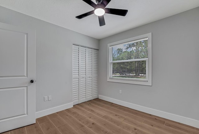 18228 48th Ave N, The Acreage, FL 33470 - unfurnished bedroom featuring wood finished floors, baseboards, a closet, and ceiling fan