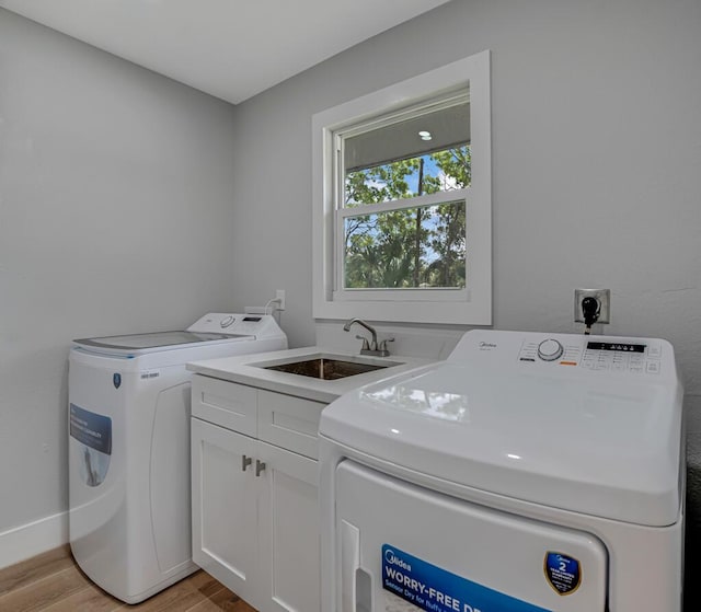 18228 48th Ave N, The Acreage, FL 33470 - washroom featuring independent washer and dryer, light wood-style flooring, cabinet space, and baseboards
