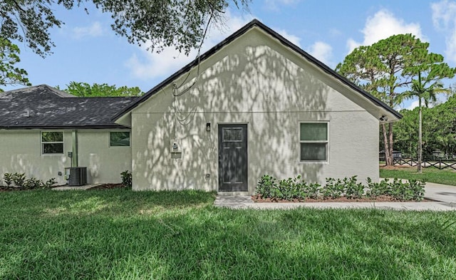 18228 48th Ave N, The Acreage, FL 33470 - rear view of house with a yard, stucco siding, a shingled roof, and cooling unit