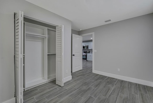 18228 48th Ave N, The Acreage, FL 33470 - unfurnished bedroom featuring wood finish floors, baseboards, and a closet