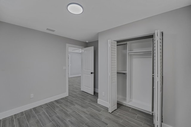 18228 48th Ave N, The Acreage, FL 33470 - unfurnished bedroom with baseboards, wood tiled floors, and a closet