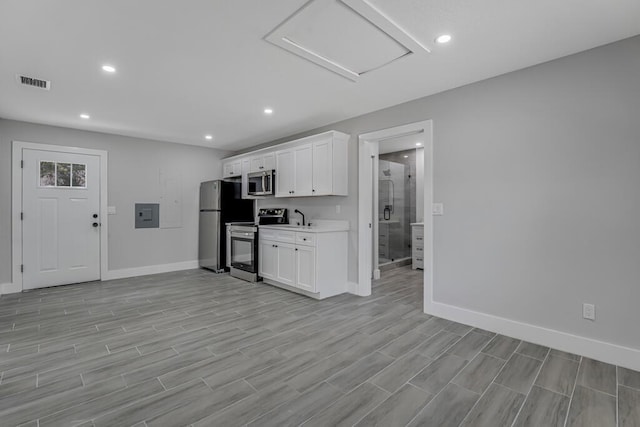 18228 48th Ave N, The Acreage, FL 33470 - kitchen featuring stainless steel appliances, electric panel, baseboards, white cabinetry, and recessed lighting