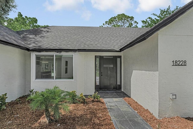 18228 48th Ave N, The Acreage, FL 33470 - entrance to property featuring a shingled roof and stucco siding