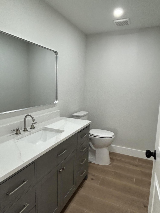 18228 48th Ave N, The Acreage, FL 33470 - bathroom featuring wood finished floors, vanity, toilet, and baseboards