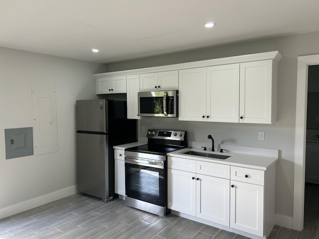 18228 48th Ave N, The Acreage, FL 33470 - kitchen featuring appliances with stainless steel finishes, a sink, baseboards, white cabinets, and recessed lighting