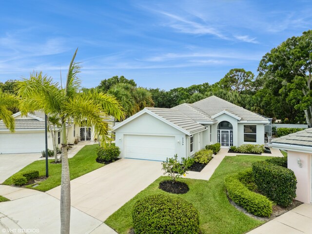 5096 SE Sweetbrier Ter, Hobe Sound, FL 33455 - single story home featuring a garage, driveway, a front lawn, and stucco siding