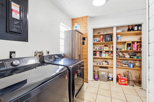 1430 SE Ocean Ln, Port Saint Lucie, FL 34983 - laundry area with washer and dryer, wooden walls, light tile patterned floors, a textured ceiling, and electric panel