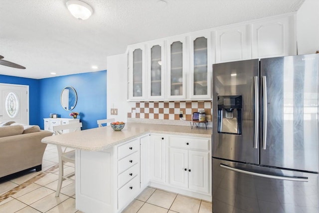 1430 SE Ocean Ln, Port Saint Lucie, FL 34983 - kitchen with stainless steel refrigerator with ice dispenser, light tile patterned flooring, a peninsula, a kitchen breakfast bar, and glass insert cabinets