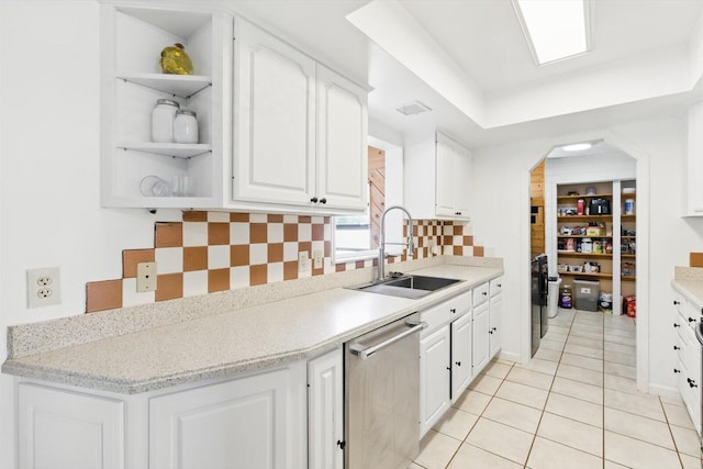 1430 SE Ocean Ln, Port Saint Lucie, FL 34983 - kitchen with stainless steel dishwasher, a sink, open shelves, white cabinets, and light tile patterned floors
