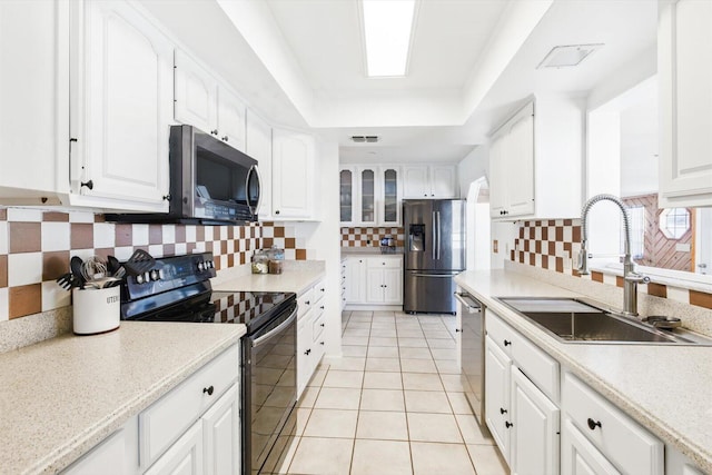 1430 SE Ocean Ln, Port Saint Lucie, FL 34983 - kitchen featuring stainless steel appliances, a sink, decorative backsplash, light tile patterned floors, and white cabinetry