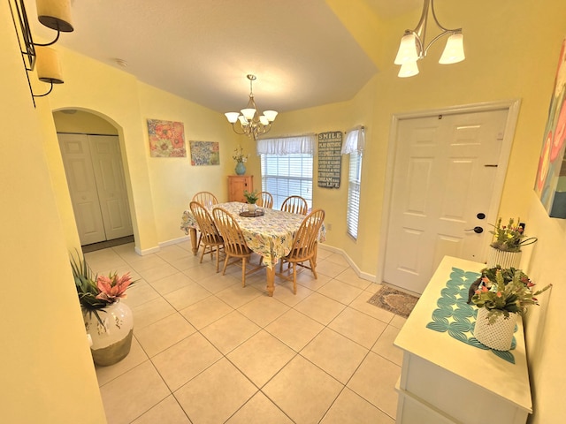 5237 NW Milner Dr, Port Saint Lucie, FL 34983 - dining area with a chandelier, arched walkways, light tile patterned floors, lofted ceiling, and baseboards