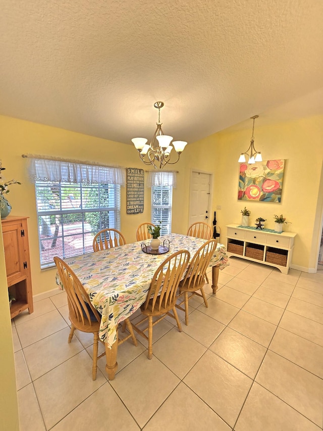 5237 NW Milner Dr, Port Saint Lucie, FL 34983 - dining area featuring light tile patterned floors, a chandelier, a textured ceiling, and baseboards