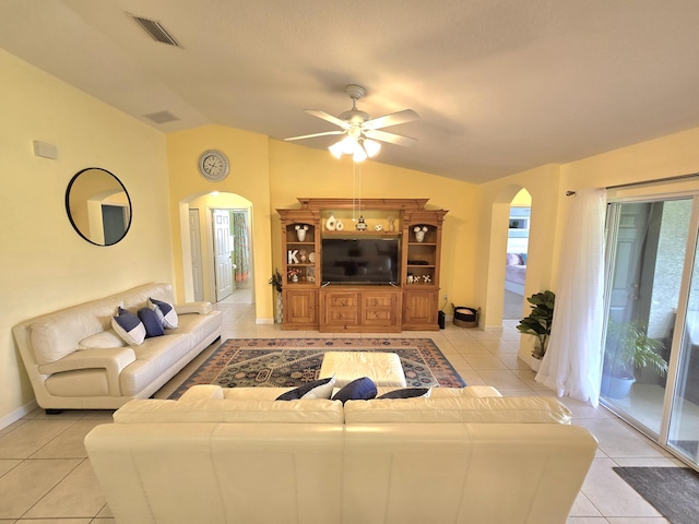 5237 NW Milner Dr, Port Saint Lucie, FL 34983 - living room featuring arched walkways, lofted ceiling, light tile patterned floors, ceiling fan, and baseboards