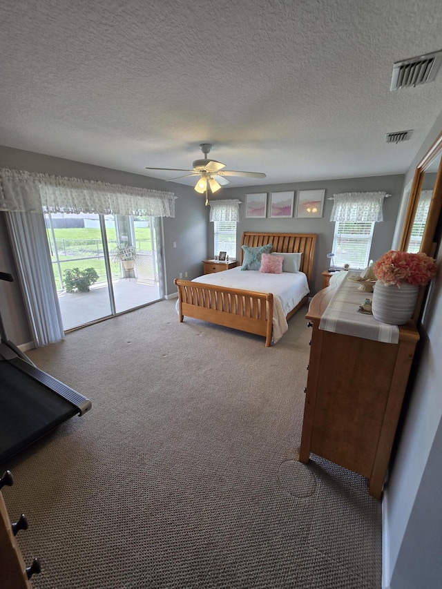 5237 NW Milner Dr, Port Saint Lucie, FL 34983 - bedroom with access to exterior, carpet flooring, a textured ceiling, and a ceiling fan