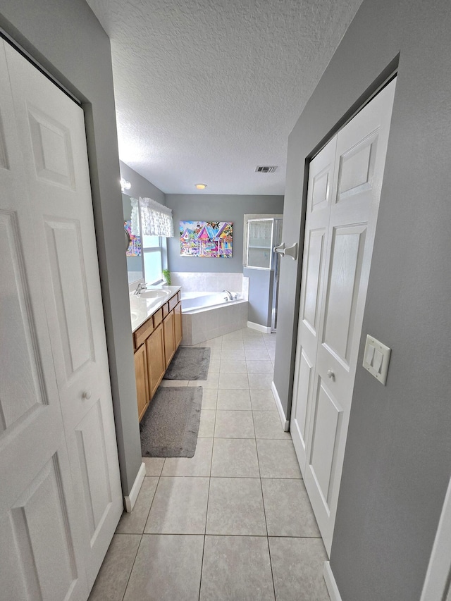 5237 NW Milner Dr, Port Saint Lucie, FL 34983 - full bathroom featuring a bath, vanity, tile patterned floors, a textured ceiling, and baseboards