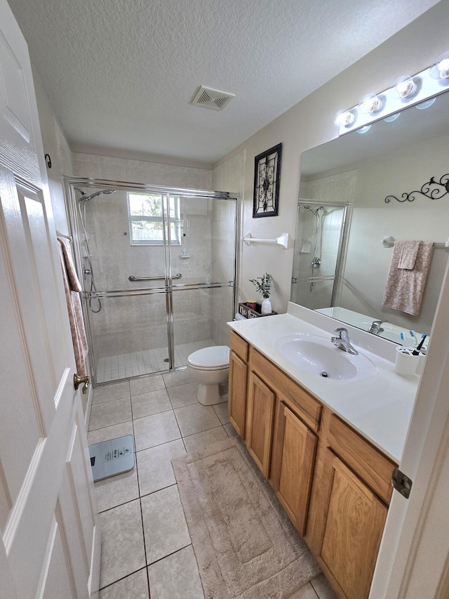 5237 NW Milner Dr, Port Saint Lucie, FL 34983 - bathroom with vanity, a stall shower, toilet, tile patterned floors, and a textured ceiling