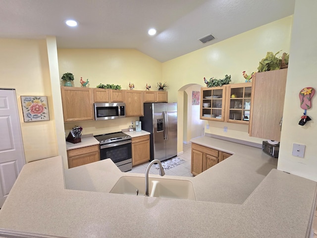 5237 NW Milner Dr, Port Saint Lucie, FL 34983 - kitchen with stainless steel appliances, a sink, arched walkways, vaulted ceiling, and light tile patterned floors
